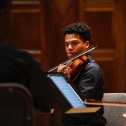 澳门威尼斯人网上赌场 student plays the violin during a concert.